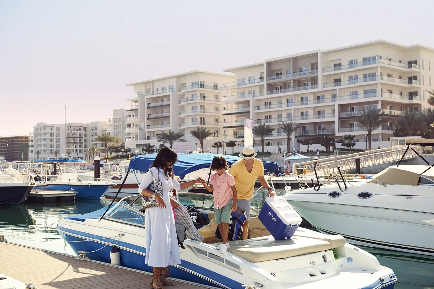 Viviendas junto al agua, yates y vida familiar en Al Mouj Marina, Mascate, Omán.